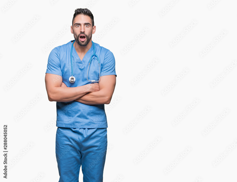 Fototapeta premium Handsome young doctor surgeon man over isolated background afraid and shocked with surprise expression, fear and excited face.