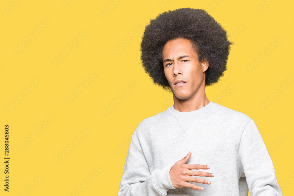 Young african american man with afro hair wearing sporty sweatshirt disgusted expression, displeased and fearful doing disgust face because aversion reaction. With hands raised. Annoying concept. Young african american man with afro hair wearing sporty sweatshirt disgusted expression, displeased and fearful doing disgust face because aversion reaction. With hands raised. Annoying concept.
