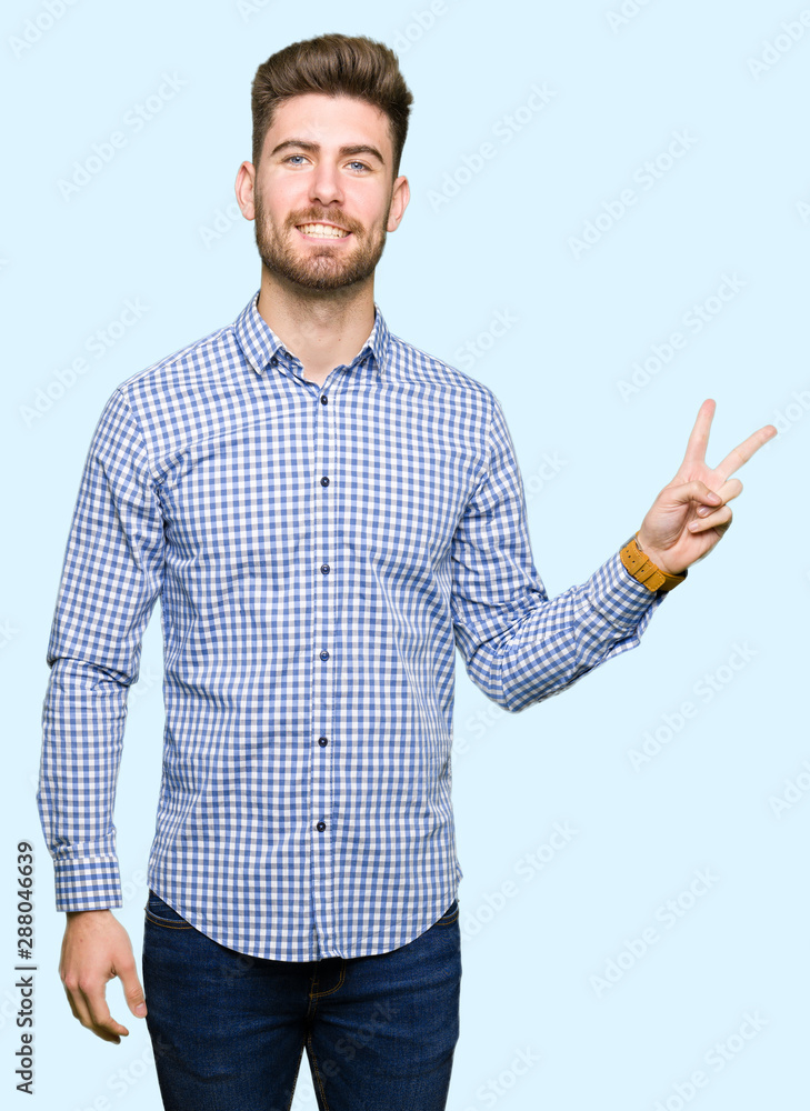 Young handsome bussines man smiling with happy face winking at the camera doing victory sign. Number two. Young handsome bussines man smiling with happy face winking at the camera doing victory sign. Number two.