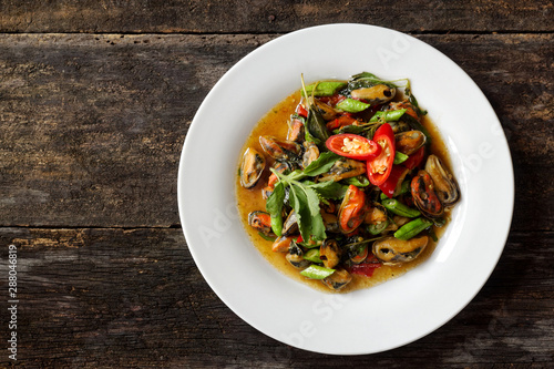 stir-fried mussels with holy basil on wood table