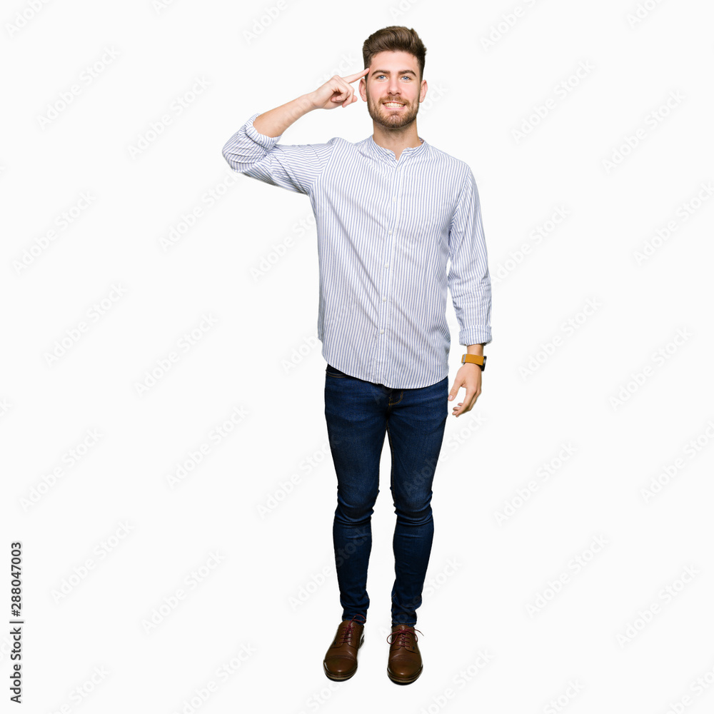 Young handsome man Smiling pointing to head with one finger, great idea or thought, good memory Young handsome man Smiling pointing to head with one finger, great idea or thought, good memory