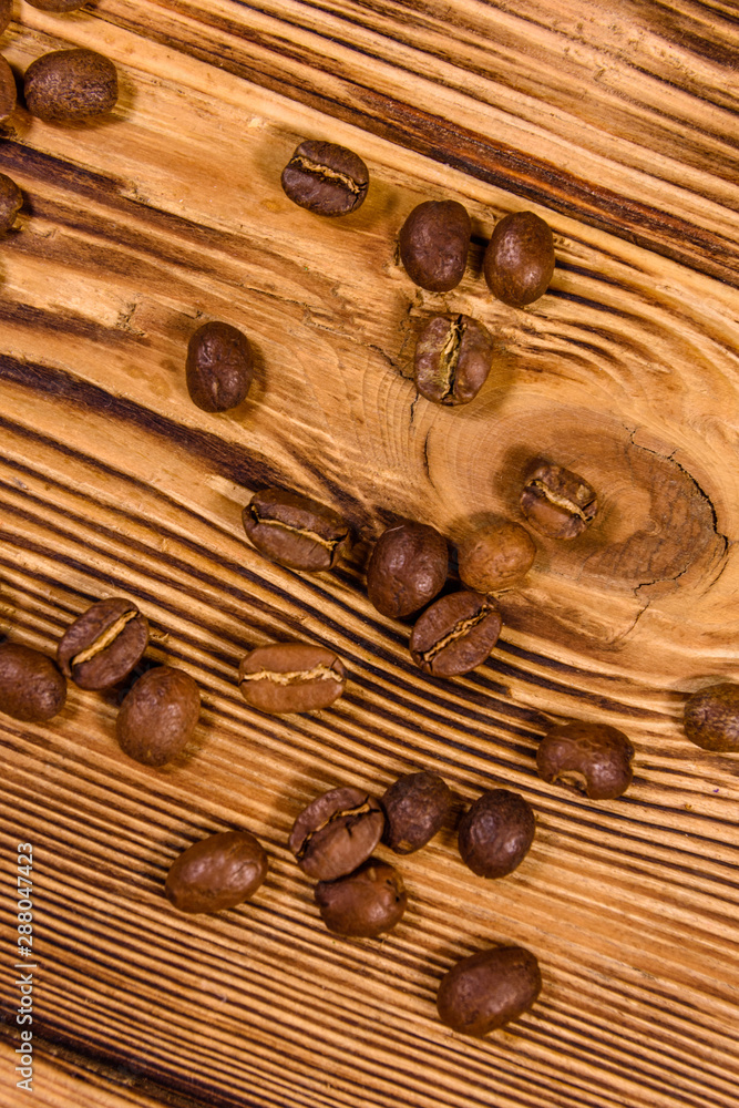Scattered coffee beans on a wooden table. Top view Scattered coffee beans on a wooden table. Top view
