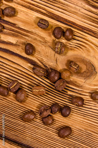 Scattered coffee beans on a wooden table. Top view