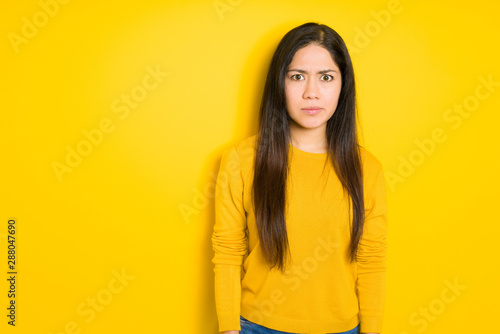 Beautiful brunette woman over yellow isolated background skeptic and nervous, frowning upset because of problem. Negative person. © Krakenimages.com