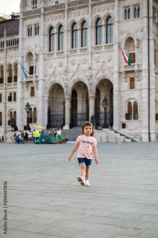 little girl child in shorts and a t-shirt stands near the Hungarian Parliament in Budapest 1 little girl child in shorts and a t-shirt stands near the Hungarian Parliament in Budapest 1