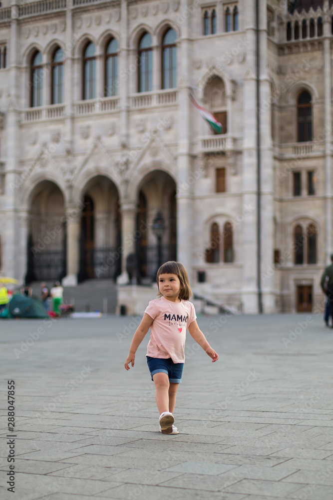 little girl child in shorts and a t-shirt stands near the Hungarian Parliament in Budapest 1 little girl child in shorts and a t-shirt stands near the Hungarian Parliament in Budapest 1