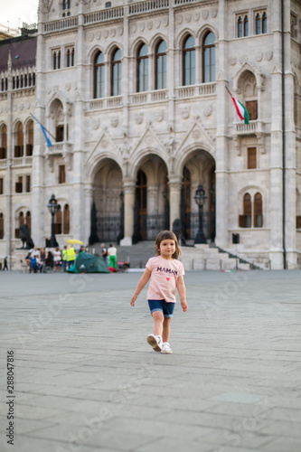 little girl child in shorts and a t-shirt stands near the Hungarian Parliament in Budapest 1 © Evgeniya Primavera