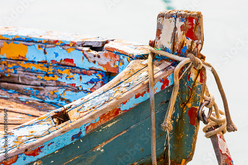 Italy, Apulia, Province of Barletta-Andria-Trani, Trani. Close-up detail of the prow of a small wooden boat, with colorful paint peeling.