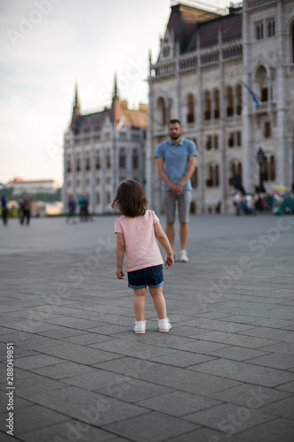 dad and little daughter are walking in the square near the Hungarian Parliament 1