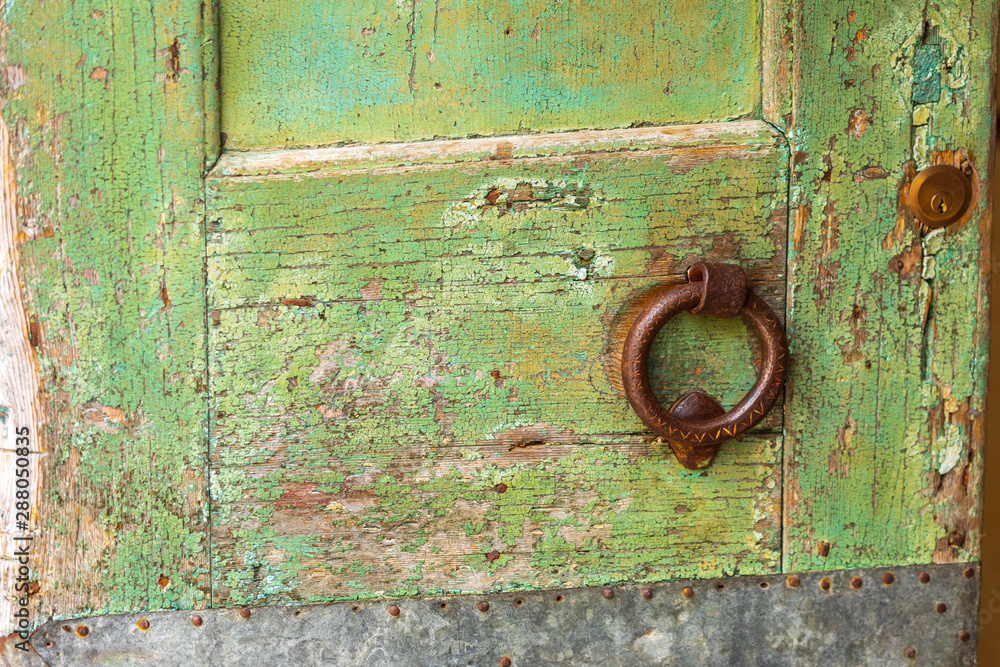 Detail of a green door with rusty iron ring. Detail of a green door with rusty iron ring.