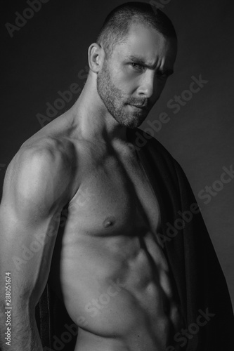 Black and White Strong stripped muscle male model in black fabric on black isolated font background