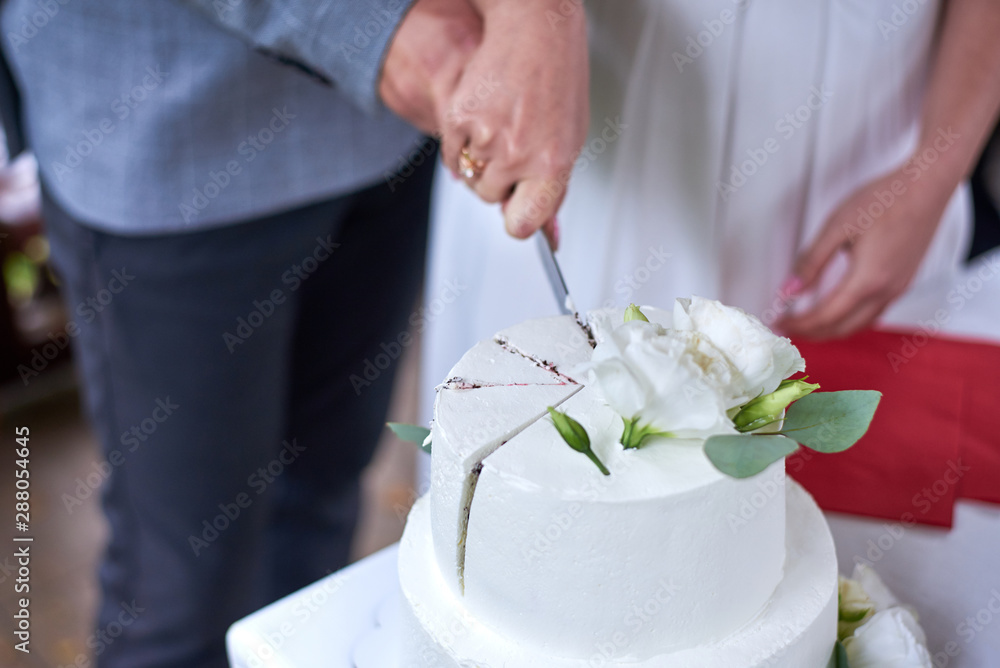 The bride and groom cut a wedding cake together. The bride and groom cut a wedding cake together.