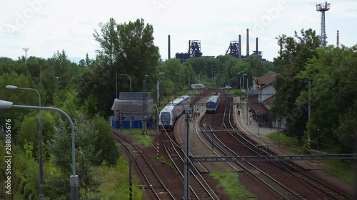 Ostrava, Czech Republic - June 2019: Elevated view of train station with people walking and train leaving the station. 4K resolution. photo