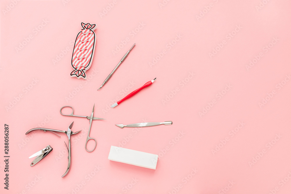 Manicure concept set on pink background. Tools for perfect nails, polishing nail buff, cuticle pusher, cuticle trimmer, nail file, nail scissors, toes separator, nail clippers, toenail clippers. Manicure concept set on pink background. Tools for perfect nails, polishing nail buff, cuticle pusher, cuticle trimmer, nail file, nail scissors, toes separator, nail clippers, toenail clippers.