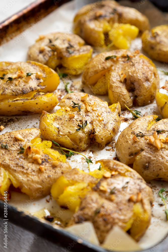 Homemade garlic thyme smashed potatoes, low angle view. Close-up. Homemade garlic thyme smashed potatoes, low angle view. Close-up.