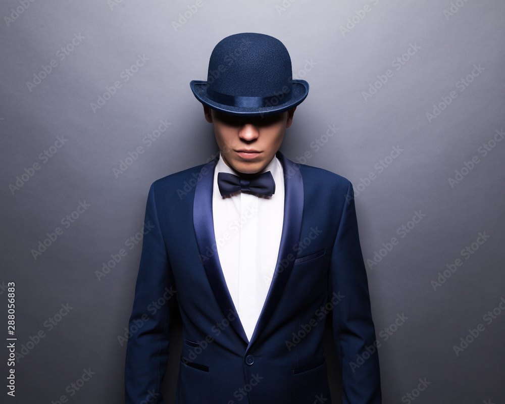 Portrait of handsome stylish man in elegant gray suit and bowler hat. Portrait of handsome stylish man in elegant gray suit and bowler hat.