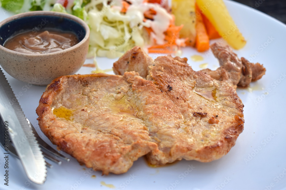  Pork steak with vegetable salads and sauces is a delicious and popular dish.