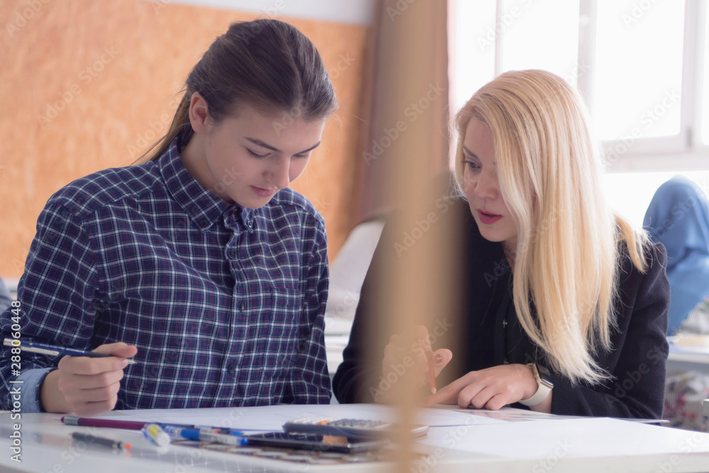 Female Architecture teacher at work. Female professor explain architectural projects to students. Beautiful female university architecture professor explain lessons to multiethnic students. Female Architecture teacher at work. Female professor explain architectural projects to students. Beautiful female university architecture professor explain lessons to multiethnic students.
