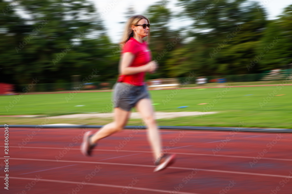 young woman on running track motion blur