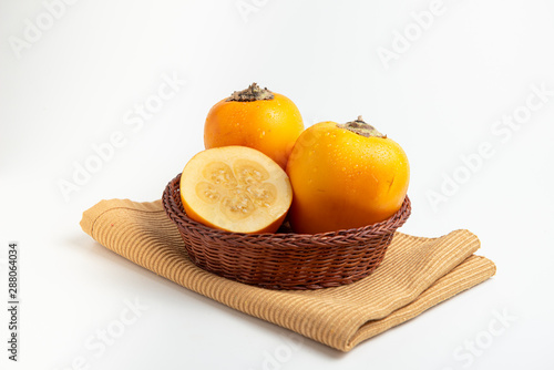 Fresh tropical fruit in a rustic bowl: cocona, white background photo