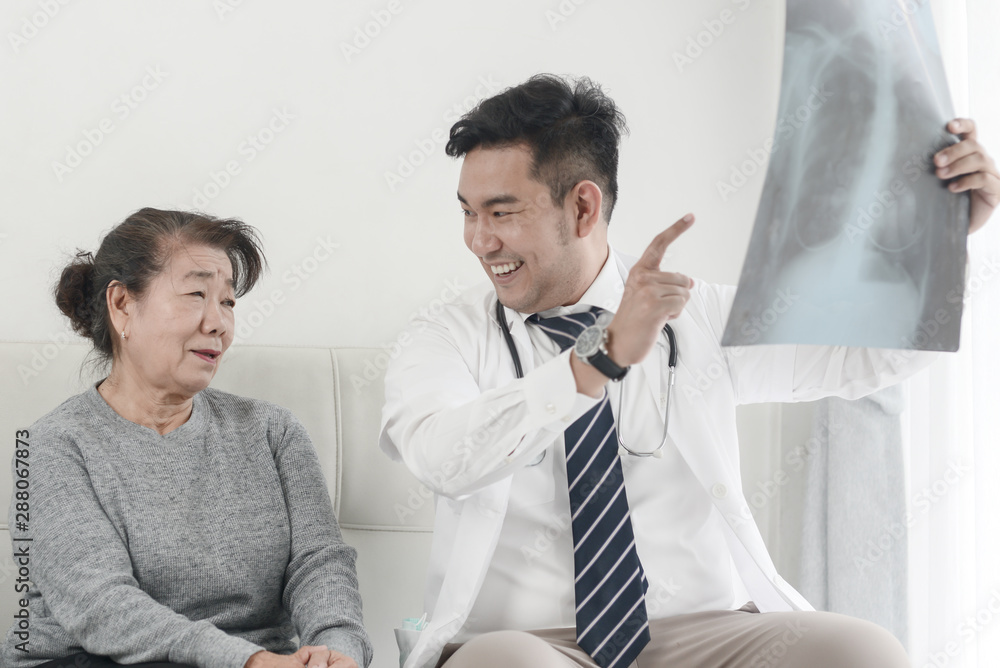Doctor showing x-ray results to elderly woman Doctor showing x-ray results to elderly woman
