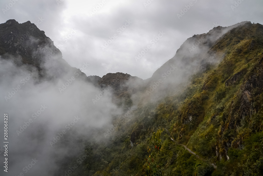 Low hanging clouds around the green mountains that stretch through the Inca trail towards Machu Picchu Low hanging clouds around the green mountains that stretch through the Inca trail towards Machu Picchu