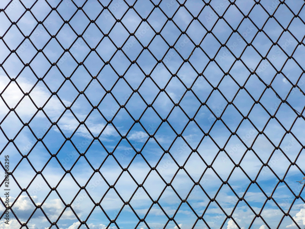 Fototapeta premium Iron wire mesh fence,chain link fence with blue sky and clouds
