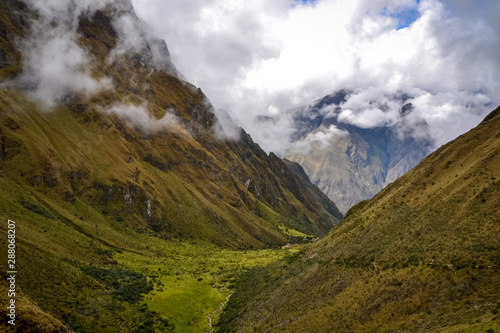 Dark green valleys dominates the landscapes around the Inca trail on this fog and overcast day in Peru