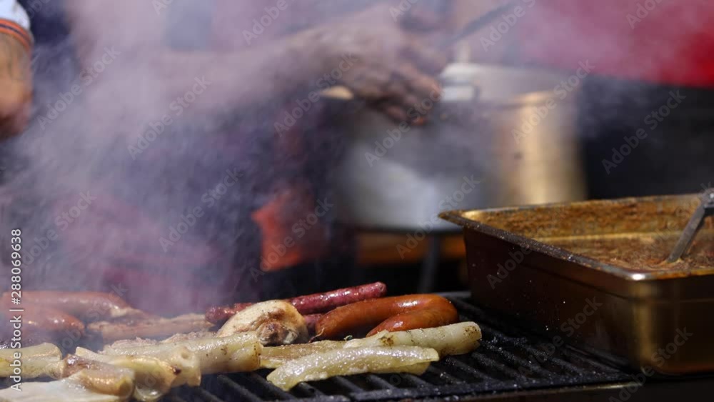 Street Food. Pork meat and sausages being cooked over hot charcoal fire Street Food. Pork meat and sausages being cooked over hot charcoal fire