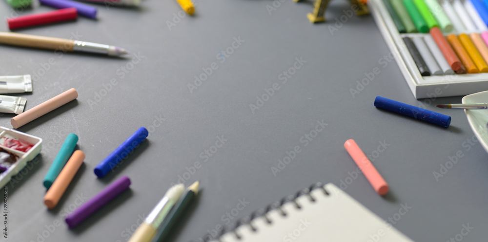 Artist creative studio with water colours, soft pastel colours and painting brushes with copy space Artist creative studio with water colours, soft pastel colours and painting brushes with copy space