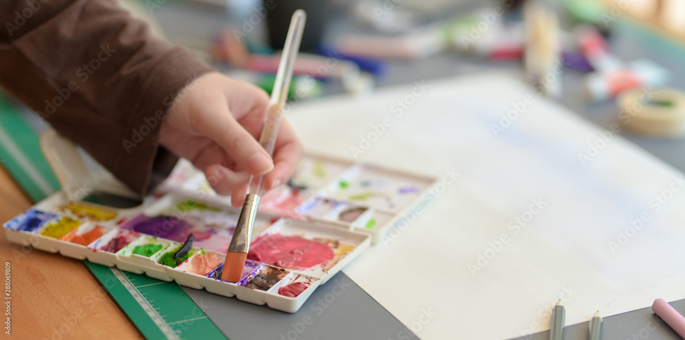 Fototapeta premium Cropped shot of female artist painting on her project with water colours
