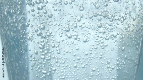 固定撮影した炭酸水の入ったコップに炭酸水を注ぎ足した後の気泡
