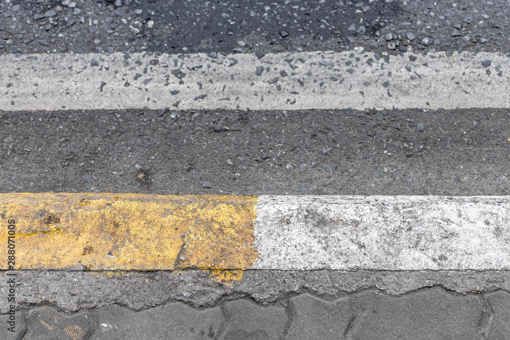 Fototapeta premium Yellow and white lines on footpath