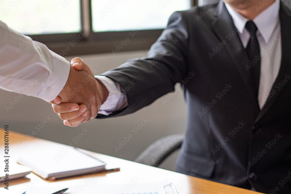 Obraz premium Close up view of business partnership handshake concept.Photo of two businessman handshaking process.businessman shaking hands in office. Collaborative teamwork