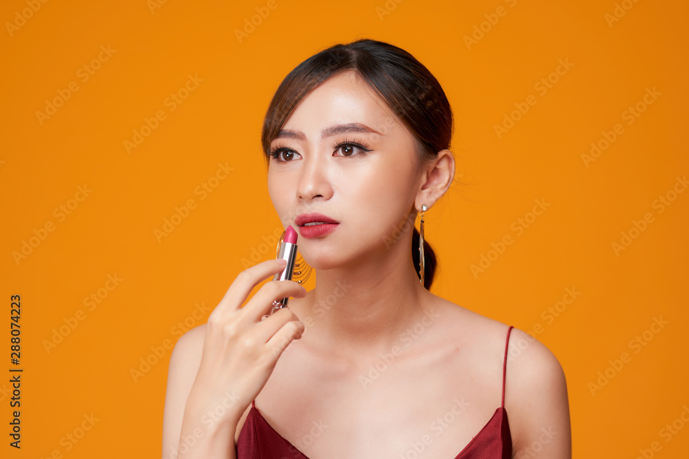 beautiful woman is applying her lips with red lipstick beautiful woman is applying her lips with red lipstick