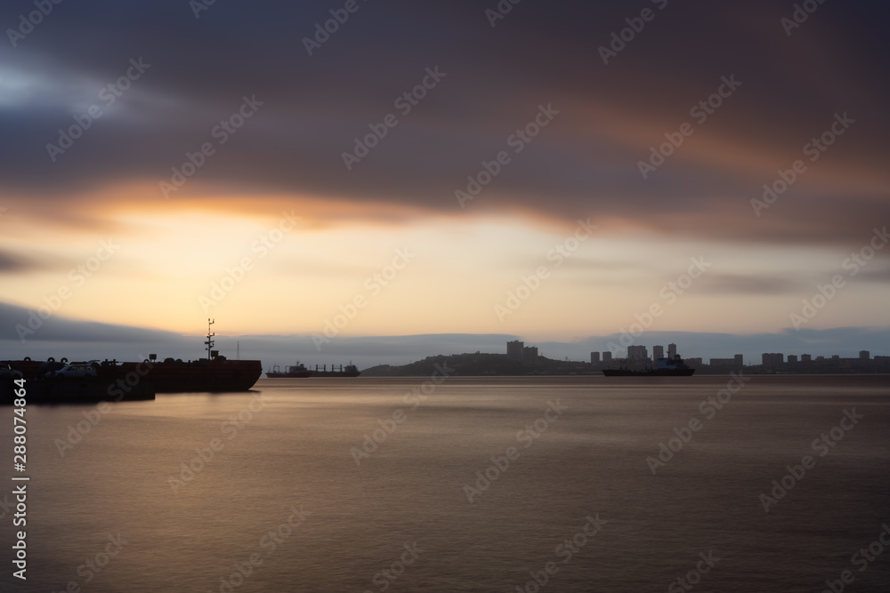 Seascape at sunset on the background of the coastline of Vladivostok
