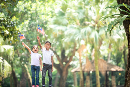 Boy and Girl with Malaysia Flag. Independence Day concept. Outdoor Setting