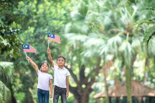 Boy and Girl with Malaysia Flag. Independence Day concept. Outdoor Setting