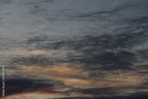 Black rain cloud with colorful twilight cloud in an evening