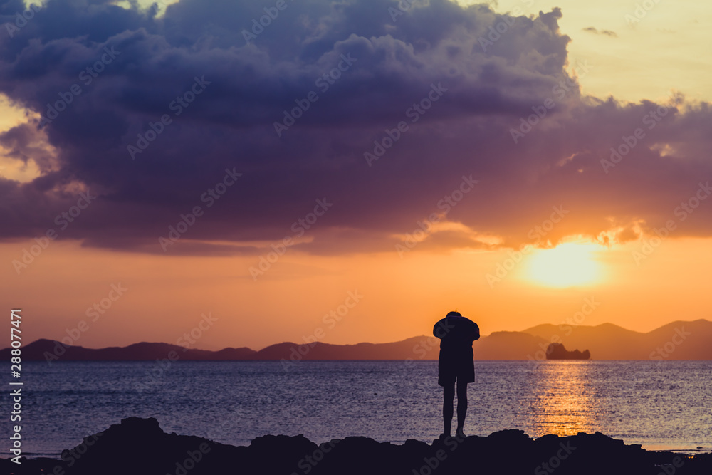 Fototapeta premium Siluate lonely man at the beach before sunset