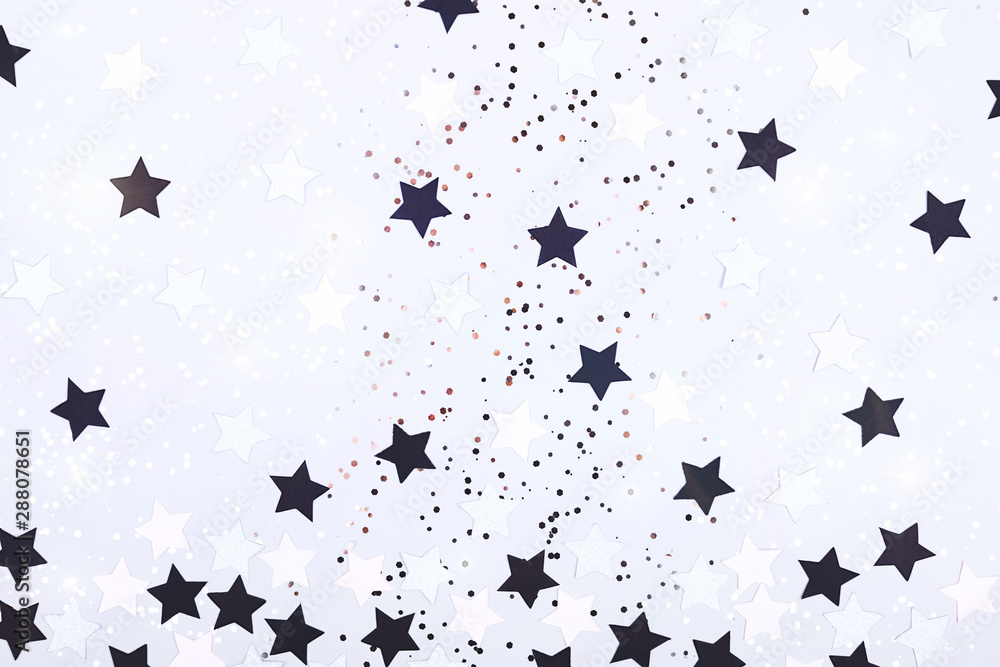 Falling confetti, glitter and sparkles on grey background.