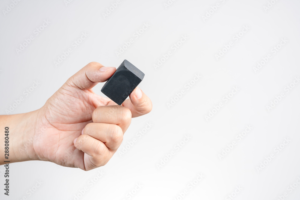 Hand holding black pencil eraser rubber with used or scrach mark Hand holding black pencil eraser rubber with used or scrach mark