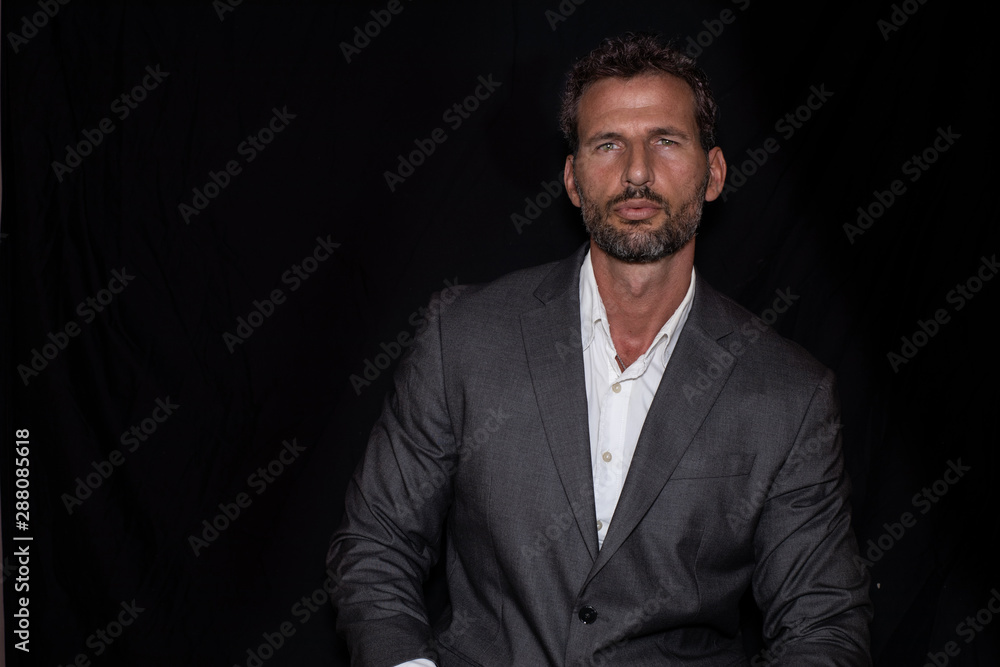 Green-eyed, handsome and sexy businessman posing with jacket and shirt and black background Green-eyed, handsome and sexy businessman posing with jacket and shirt and black background