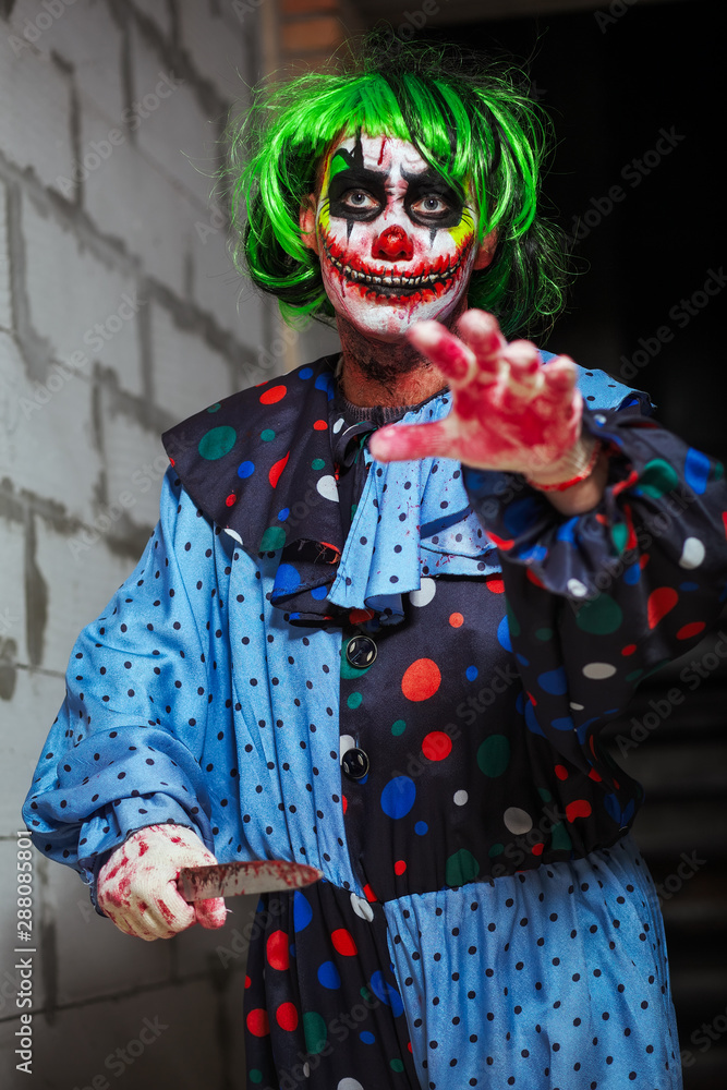 Crazy clown with a knife. Halloween concept