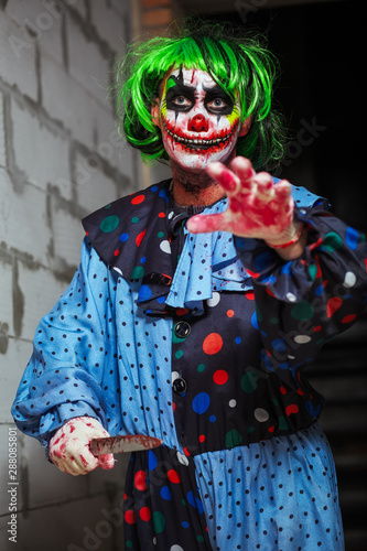 Crazy clown with a knife. Halloween concept