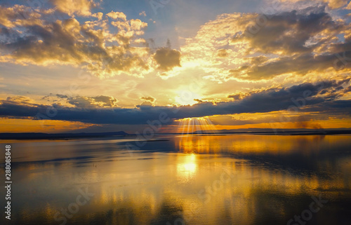 Aerial view, Beautiful Orange and red dramatic colors of sunset and cirrus clouds above the sea. Sky blue and orange natural dawn composition over the sea, Warm colors reflect the water surface.