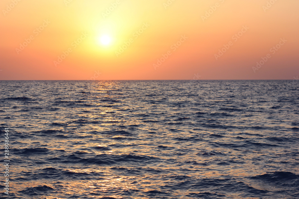 sunset over the sea with waves.