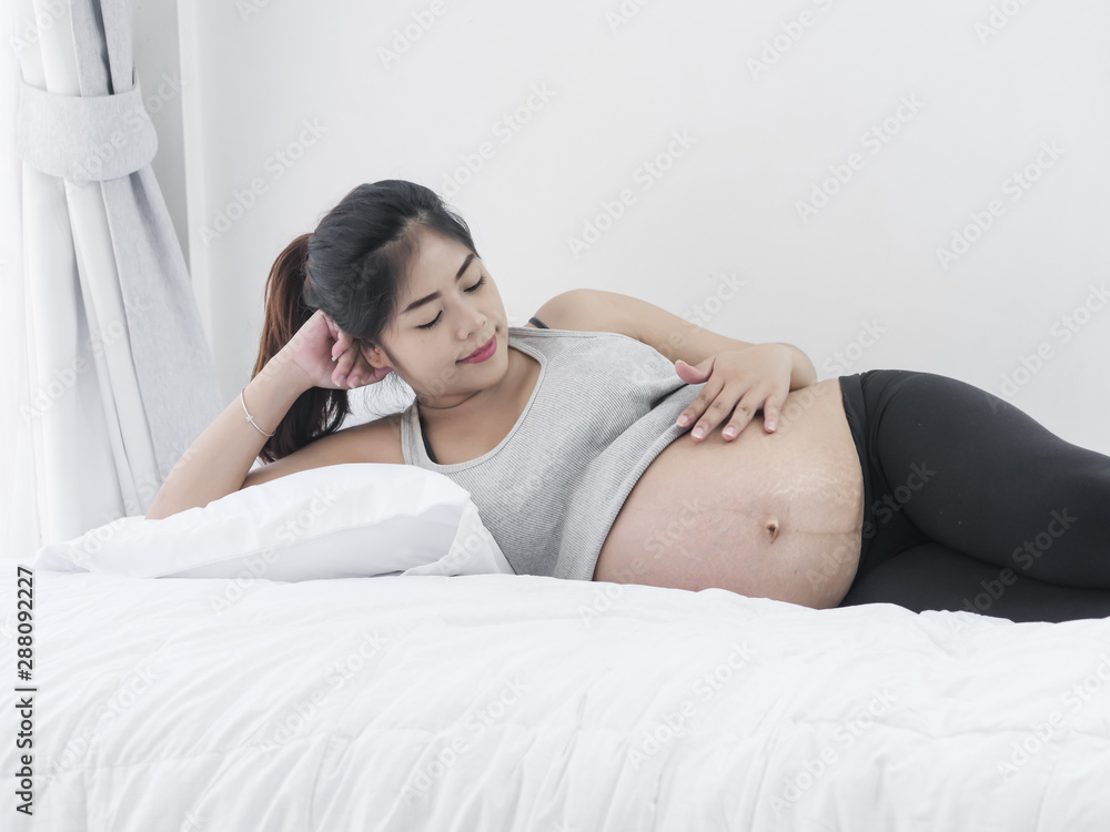 Asian pregnant woman resting on bed at home, lifestyle concept. Asian pregnant woman resting on bed at home, lifestyle concept.