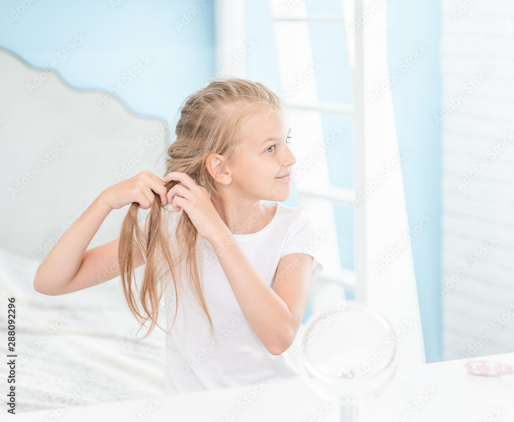 Young girl braids herself in the morning at home Young girl braids herself in the morning at home