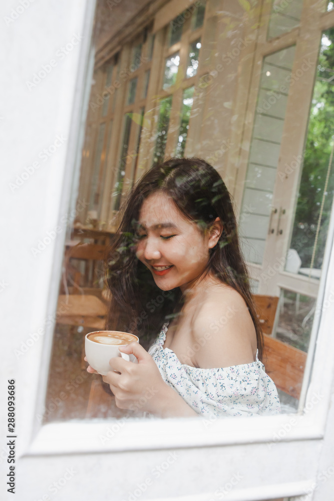 Asian woman holding cup of hot latte art at coffee cafe . Asian woman holding cup of hot latte art at coffee cafe .
